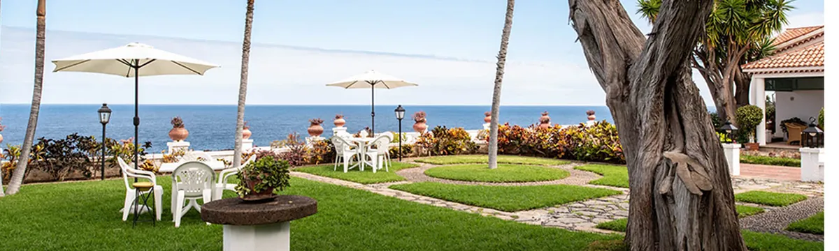 Jardín con sombrillas y vistas al mar